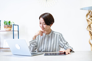 パソコンとタブレットを使い仕事をする女性
