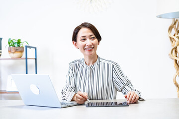 パソコンとタブレットを使い仕事をする女性