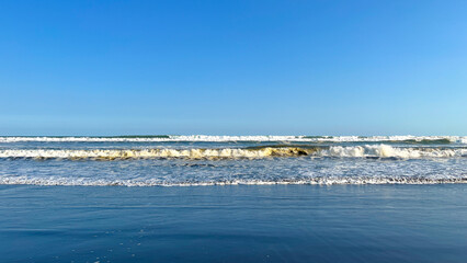 Ocean Waves Viewed from the Shoreline under Clear Blue Sky