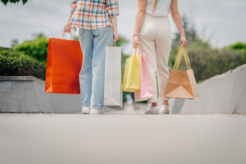 Women walking away carrying shopping bags after purchases