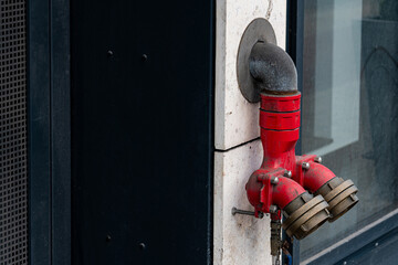 A bright red fire hydrant mounted on building exterior