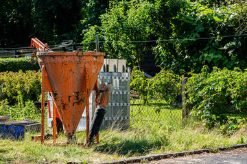 Construction equipment and hopper in a green garden area
