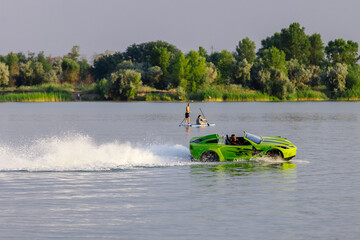 Young man riding a jet ski shaped like a car during summer vacation. Concept of speed, freedom and...