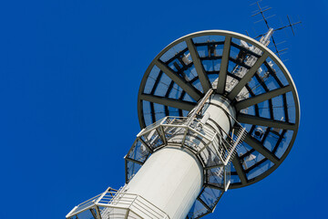 Telecommunications tower against a clear blue sky.