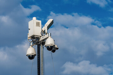 Surveillance system installed on a tall pole at daytime.
