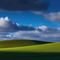 Obraz premium Undulating green hills bathed in sunlight under a dramatic, partly cloudy sky