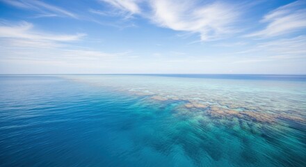 Obraz premium Vast Ocean Panorama with Turquoise Waters and Vibrant Coral Reefs Under a Bright Blue Sky