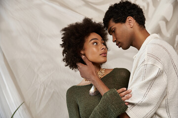 Young couple sharing a heartfelt moment in a stylish indoor setting during golden hour