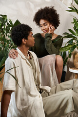 Young couple sharing intimate moments in a stylish, plant filled environment at sunset