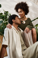 Young couple in a stylish embrace surrounded by lush greenery expressing deep love and connection