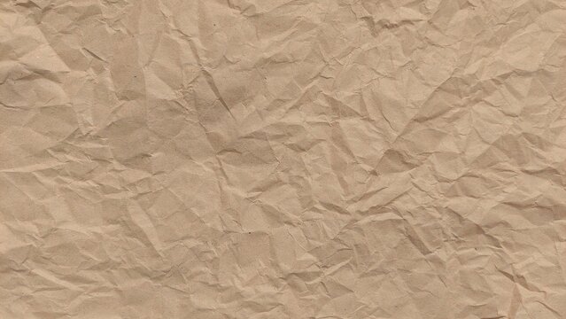 Crumpled old rough brown paper background with natural folds and creases. Crumpled old brown vintage paper surface texture for background. Crumpled brown recycle paper texture.