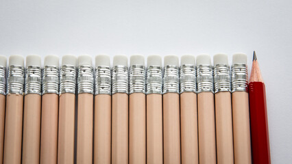 Standing Out from the Crowd – One Red Pencil Among Identical Erasers