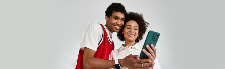 Young couple sharing joyful moments while viewing their favorite memories on a smartphone together
