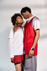 Young couple sharing a tender moment in stylish urban fashion under soft lighting
