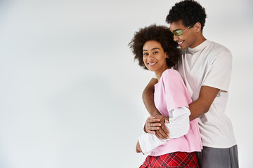 Young couple embraces in stylish attire, showcasing love and connection in contemporary setting