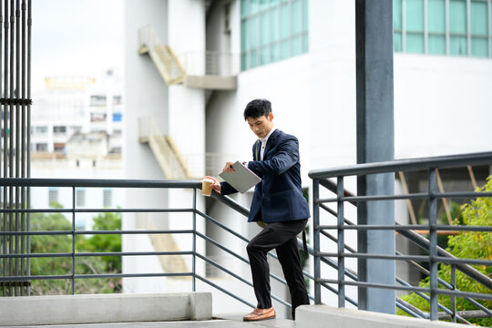 Asian businessman checking time on his wristwatch during a busy day