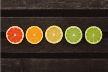 slices of citrus fruits on a dark wooden surface.

