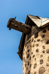 A close-up view of a historic stone windmill with a wooden beam extending from the roof against a...
