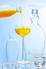 Pouring Orange Juice into Elegant Glass on Ice