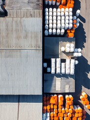 Top view showcases neatly arranged industrial materials besides the textured metallic building roof under sunlight