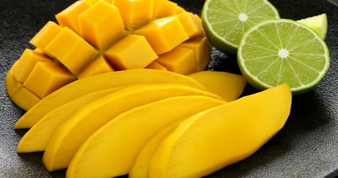 Fresh mango and lime slices arranged on a plate