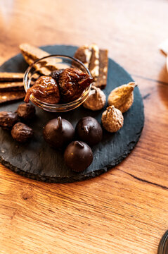 Rustic slate board with assorted fig preparations and gourmet chocolate delights
