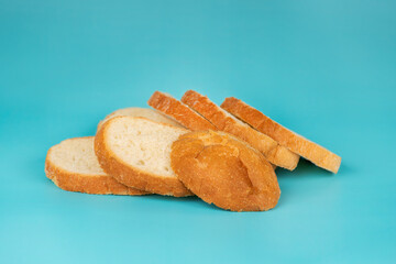 Neatly sliced white bread loaf arranged on a vivid blue background, showcasing soft texture and golden crust.