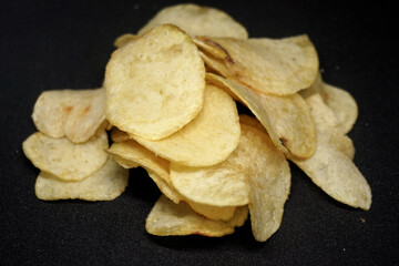 Crispy Poteto chips  in a bowl on black background 