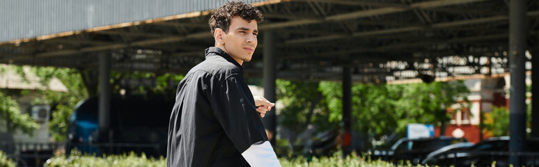 Young man enjoying a sunny day at the park while taking a moment to reflect and relax