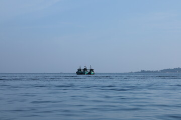 Obraz premium Tranquil Ocean Scene with Distant Fishing Boats at Dawn