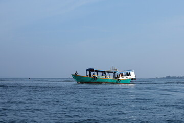 Obraz premium Serene maritime transport scene with a local ferry boat cruising on the open ocean under a clear blue sky IMG_0733.JPG