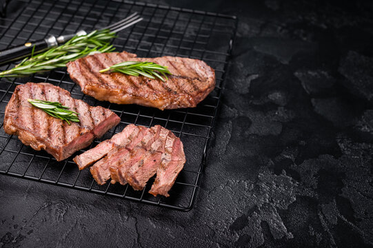 Grilled Top blade steak, shoulder beef meat. black background. top view