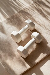 Dumbbells placed neatly on a soft neutral-toned  mat, white-beige background with soft natural light and gentle shadows, clean minimalist fitness setup, calm and aesthetic wellness vibe