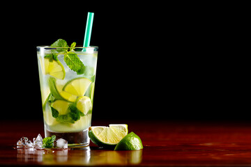 Refreshing mojito cocktail with lime and mint on a dark background