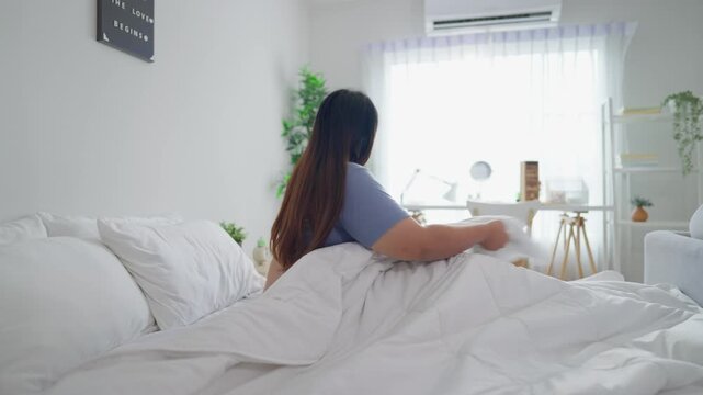 Asian plus-size woman in pajamas wake up in the morning with happiness. 