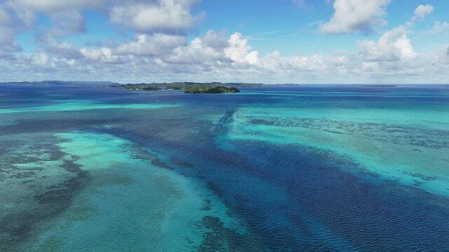 Scenic drone shot sweeping across the crystal blue waters and islands off the coast of Palau.