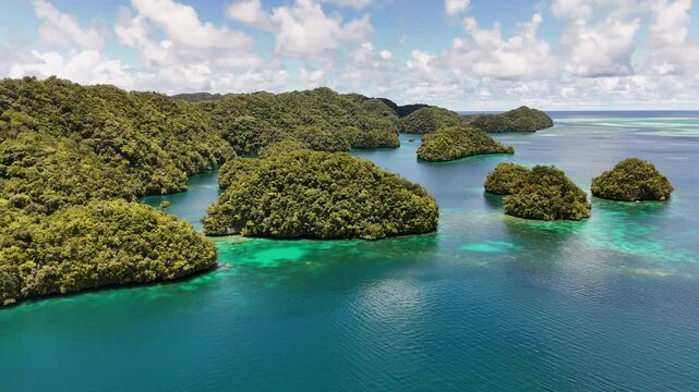 High-quality aerial drone shot panning and showcasing the crystal blue waters and islands of Palau.