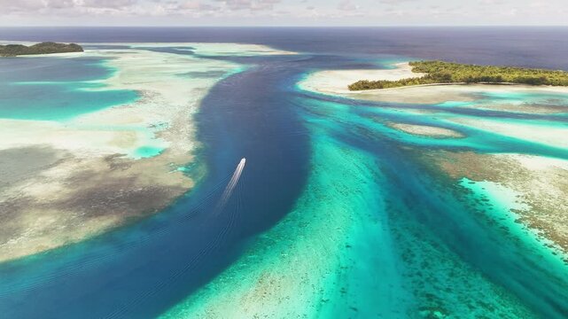 Impressive cinematic drone wide shot over crystal blue waters and islands within Palau&rsquo;s archipelago. Wide shot of boat in the water