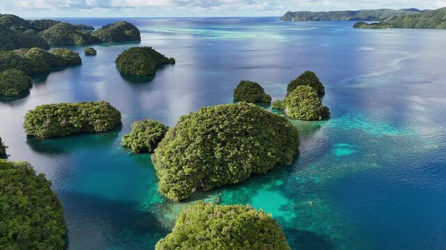 Epic cinematic aerial drone shot encircling and showcasing the tropical waters and emerald island dots of Palau.