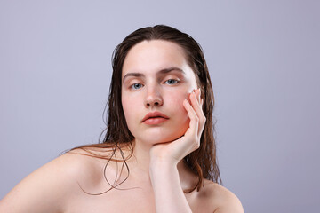 Portrait of woman with natural skin complexion on grey background, closeup