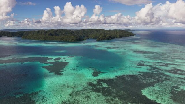 Epic aerial clip circling and revealing the clear tropical waters and exotic landforms of the islands of Palau. Wide cinematic drone shot.