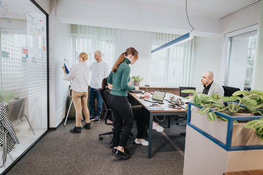 Group of associates working together on a project in a collaborative workspace, focusing on strategy and innovation while utilizing digital tools and teamwork to achieve organizational goals