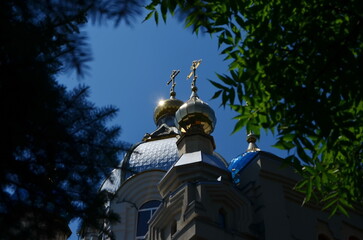 view of the domes of the Church of St. Panteleimon in Essentuki, Russia, through the foliage of...
