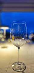 A glass of chilled white wine against a blurred background in a restaurant on the Ligurian Riviera in the summer of 2025.