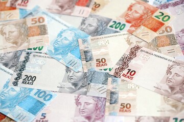 Brazilian reais banknotes. The current Brazil real money bills lies on table in big amount