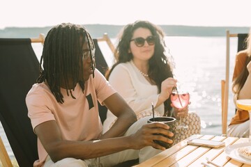 Friends enjoying drinks and conversation at a beachside cafe