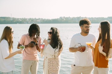 Friends enjoying drinks by the lake on a sunny day