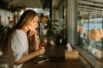 Young woman sipping a drink at a cafe table