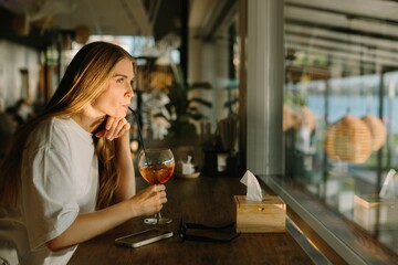 Young woman enjoying a refreshing drink at a cafe