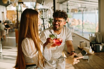 Friends toasting cocktails in a modern cafe